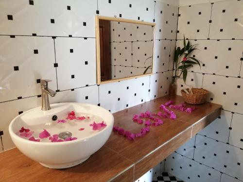 a bathroom with a bowl sink and flowers on a counter at The Hidden Oasis Bungalows in Kampot