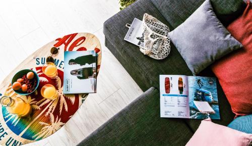 a table with a magazine and a book on a couch at Costa del Kryspi Całoroczne Domy na Wodzie in Cholerzyn