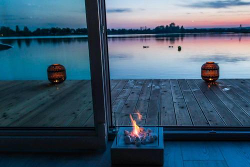 a fire on a dock with a view of a lake at Costa del Kryspi Całoroczne Domy na Wodzie in Cholerzyn