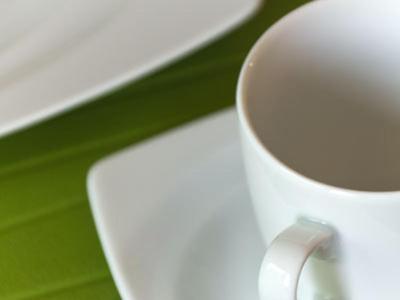 a white coffee cup sitting on top of a table at Bed & Breakfast BonnaNotte in Essen