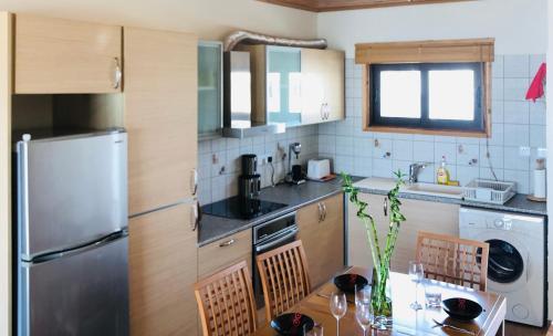 uma cozinha com uma mesa e um frigorífico em Buddha Suites em Pafos
