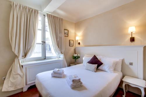 - une chambre avec un grand lit blanc et une fenêtre dans l'établissement Les Quatre Dauphins, à Aix-en-Provence