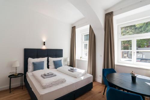 sypialnia z łóżkiem, stołem i oknami w obiekcie easy flat Sankt Elisabeth w Wiedniu