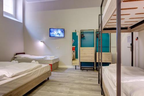 a room with two bunk beds and a tv at MEININGER Roma Termini in Rome