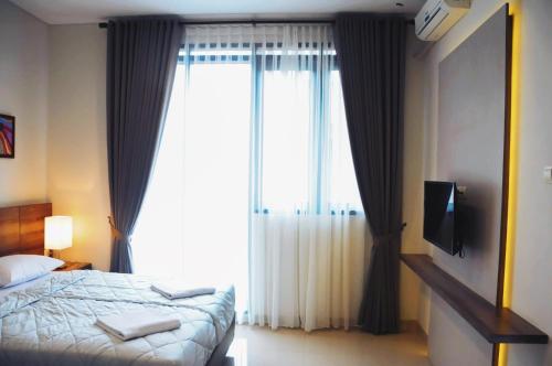 a bedroom with a bed and a large window at Rumah Mutiara in Bandung
