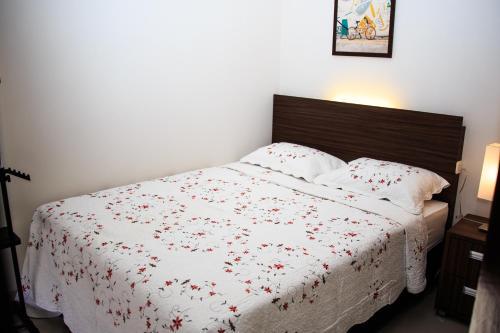 a bedroom with a white bed with red flowers on it at Rumah Mutiara in Bandung