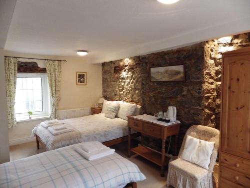 a bedroom with two beds and a desk and chair at Aber Cottage B&B in Dolgellau