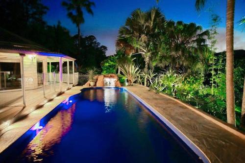 a swimming pool in the backyard of a house at Noosa hinterland Hidden valley retreat in Cooloolabin