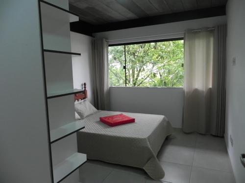 a small bedroom with a bed and a window at Aconchego e Requinte no Centro in Petrópolis