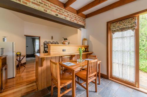 eine Küche und ein Esszimmer mit Tisch und Stühlen in der Unterkunft BRIDGE COTTAGES Sargeants & Armoury Cottages 1823 - HISTORY & CHARM in Richmond