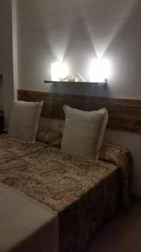 a hotel room with a bed with two pillows at Habitacion con baño privado in Santa Cruz de Tenerife