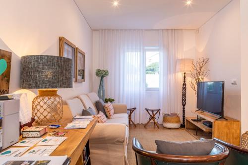 een woonkamer met een bank en een tv bij Toi et Moi-Guests speek for us! in Ponta Delgada