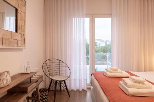 Toi et Moi-Guests speek for us! في بونتا ديلغادا: غرفة نوم بسرير وكرسي ونافذة