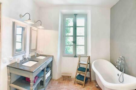 y baño con lavabo, bañera y espejo. en La Bastide en Saint-Julien