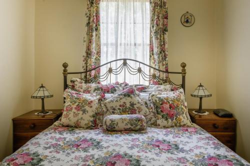 ein Schlafzimmer mit einem Bett mit Kissen und einem Fenster in der Unterkunft BRIDGE COTTAGES Sargeants & Armoury Cottages 1823 - HISTORY & CHARM in Richmond