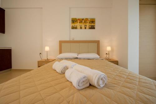une chambre avec un grand lit avec des serviettes dessus dans l'établissement Alexander's House, à Parga