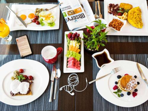 a table with plates of breakfast food on it at ibis Muscat in Muscat