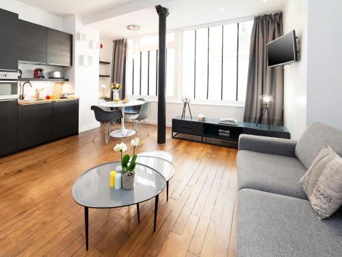 un salon avec un canapé et une table dans l'établissement Studios de Charme à Montmartre, à Paris