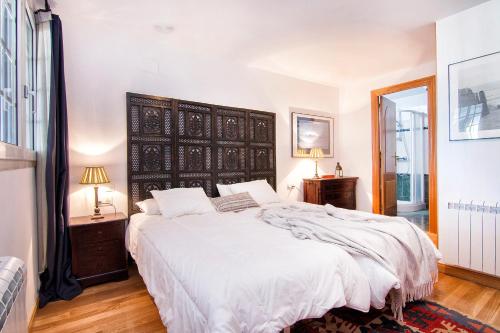 - une chambre avec un grand lit et des draps blancs dans l'établissement IMEDA TRIPLEX MULHACEN, à Sierra Nevada