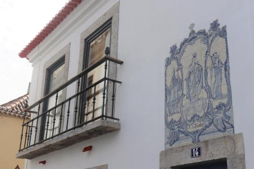 a building with a balcony and a mural on the side of it at Casa Gil Vicente in Almada