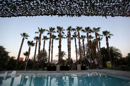 a pool with palm trees in the background at Casa Taos in Marrakech