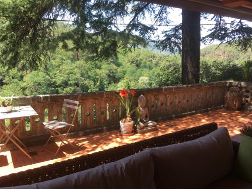 a patio with a couch and a table with a view at Le Mas Fraissinet in Saint-Jean-de-Valériscle