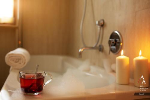 a cup of tea and two candles on a bathroom sink at Alp Apartments - Stevenin11 in Aosta