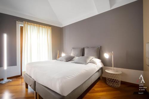 um quarto com uma grande cama branca e uma janela em Alp Apartments - Stevenin11 em Aosta