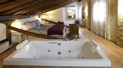 a large bath tub in a room with a bed at Casa Rural Lakoak in Garínoain