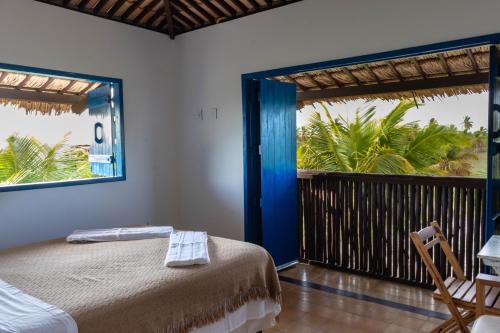 a bedroom with a bed and a balcony at Casa Corveta in São Miguel do Gostoso