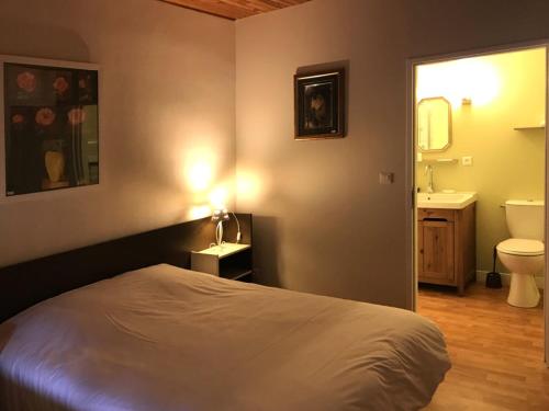 1 dormitorio con 1 cama y baño con lavamanos en Hôtel l'Annexe, en Moux-en-Morvan