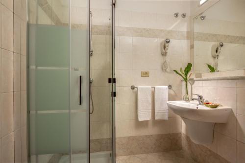 a bathroom with a glass shower and a sink at Hotel Dorica in Rome