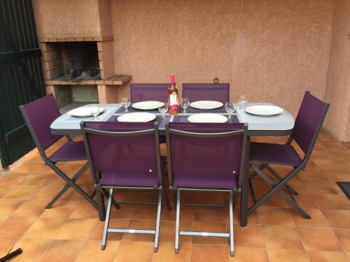 サン・シプリアンにあるVilla 33 résidence Les Pierres de Jadeの紫色の椅子とワイン1本
