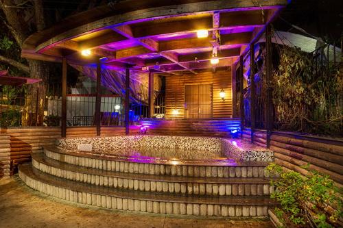 a set of stairs leading to a building with purple lights at The Boulevard by StayVista - A city-center villa boasting a private plunge pool, Jacuzzi & a revitalizing rain shower in Lonavala