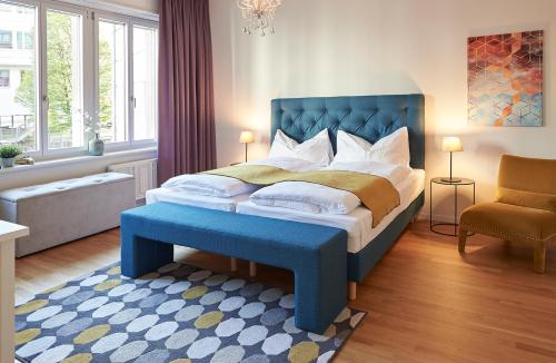 Schlafzimmer mit einem großen Bett mit blauem Kopfteil in der Unterkunft Neustadt Apartments managed by Hotel Central Luzern in Luzern