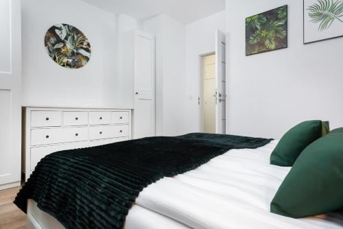 - une chambre avec une couverture noire sur un lit dans l'établissement Apartments Rzeczypospolitej by Renters Prestige, à Varsovie