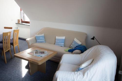 een woonkamer met een bank en een tafel bij Ferienwohnungen-Neue-Tiefe-Wohnung-Kleiderbuegel in Neue Tiefe Fehmarn