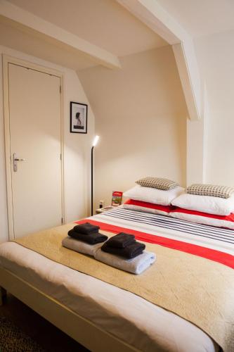 a bedroom with a large bed with towels on it at Kuwadro Guesthouse Jordaan in Amsterdam