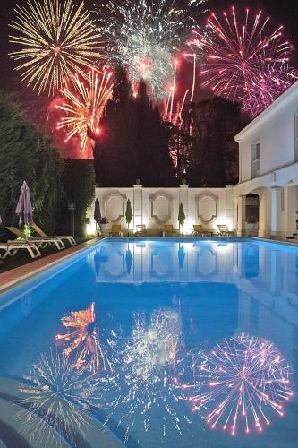 a swimming pool with fireworks in the background at Hôtel Mireille in Arles