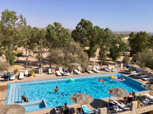 ein Pool in einem Resort mit Leuten, die darin spielen in der Unterkunft Camping & Hôtel Le Calme in Essaouira