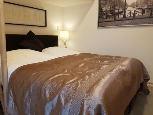 1 dormitorio con 1 cama con manta marrón en B&B Wladimir Studios, en Ámsterdam