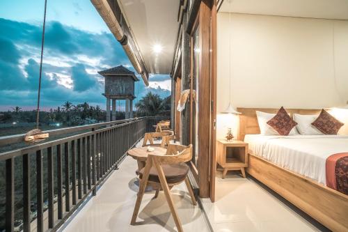 a bedroom with a bed and a balcony at Three Dewi's Guest House in Ubud