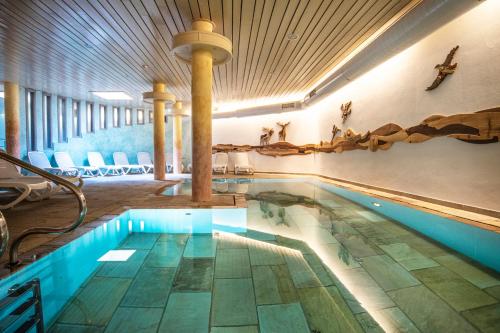 a swimming pool in a building with a pool at Al Sole Clubresidence in Canazei