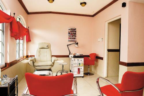 a hair salon with red chairs and a hair dryer at Rondel Village in Negril