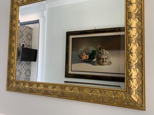 a mirror on a wall with a statue in it at Palazzo Samà in Catanzaro