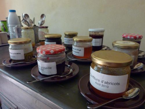 een toonbank met veel potten jam op schalen bij Des Lits Sur La Place in Hérépian