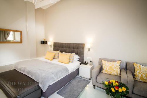 a bedroom with a bed and a couch at The Walden House in Cape Town