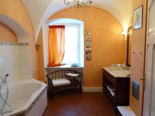 a bathroom with a tub and a chair and a window at Gutsherrenstube in Großheringen