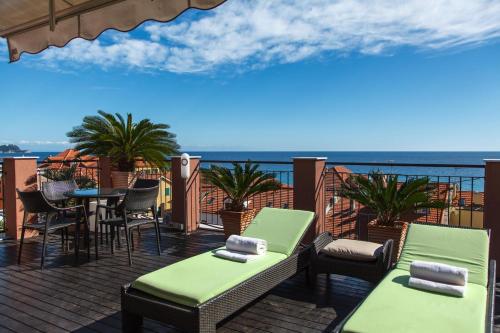 a balcony with chairs and tables and a view of the ocean at Allegroitalia Alassio Rosa in Alassio