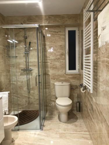 ein Bad mit einem WC und einer Glasdusche in der Unterkunft CHESS CITY in Salamanca